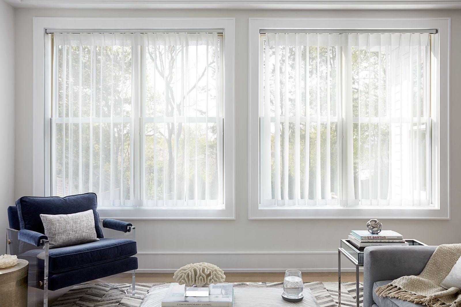 Melody vertical sheers in white hang in two large side by side windows in a modern living room.