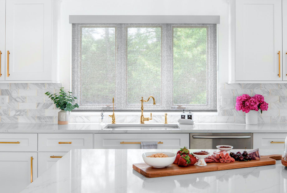 Light gray solar shades behind the sink in the modern kitchen provide inviting warmth while also saving electricity.