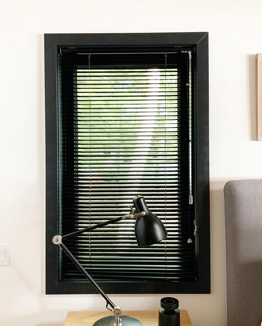 Aluminum blinds look custom in a black window frame 