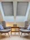 Skylight shades in a room with two chairs, adding style and light control to the space