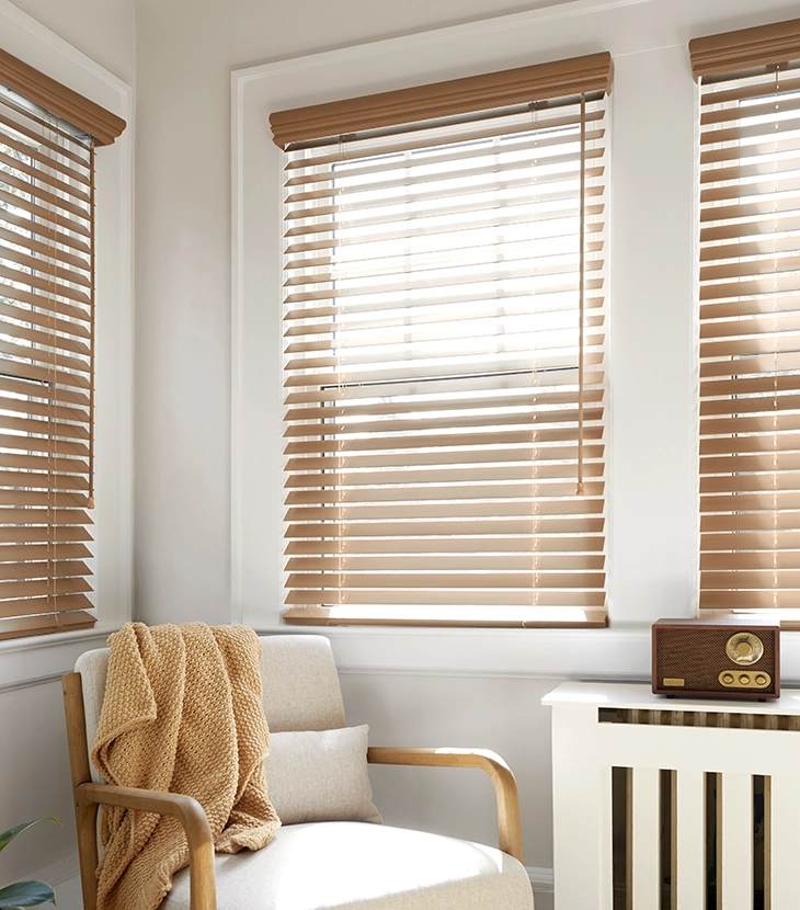 Light shines through beautiful real wood blinds in a modern living room.