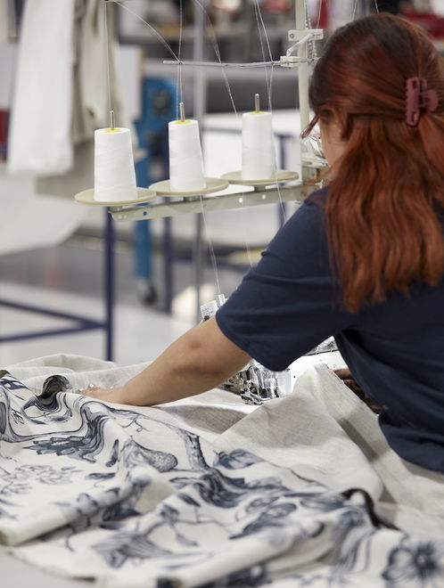 Factory workers crafting drapery and curtains, ensuring high-quality materials and precision for custom window treatments