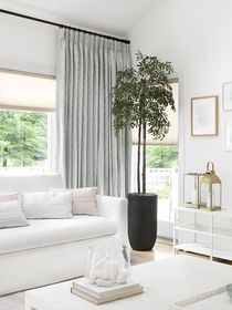 Layered window treatments with roller shades and curtains for the living room, combining light control, privacy, and style