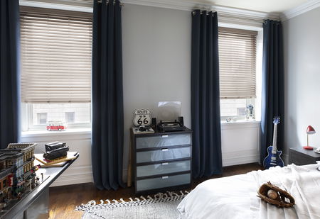 Blue velvet curtains paired with tan aluminum blinds in a modern kids bedroom