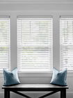 Classic white faux wood blinds, offering a durable and stylish replica of real wood for light control and privacy.