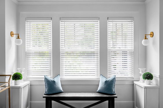 Classic white faux wood blinds, offering a durable and stylish replica of real wood for light control and privacy.