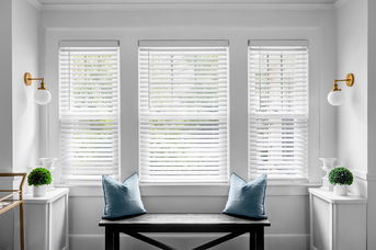 Classic white faux wood blinds, offering a durable and stylish replica of real wood for light control and privacy.