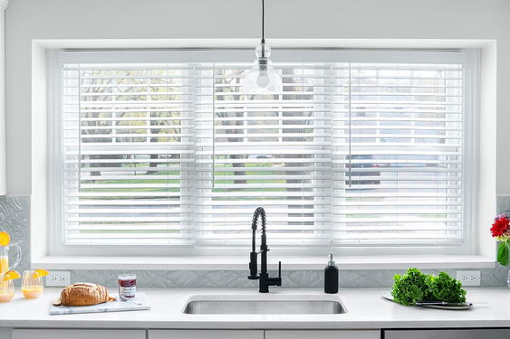 Faux wood blinds for windows in bright white and wood tones, combining style and durability for effective light control and privacy.