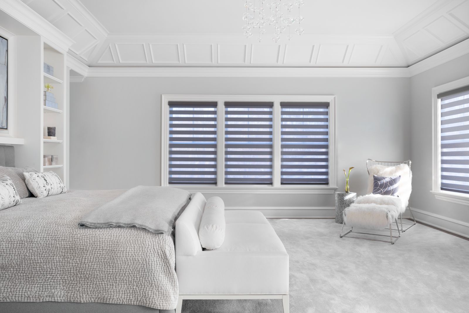 Cascade sheer shades with alternating stripes of grey and transparent material in a bedroom