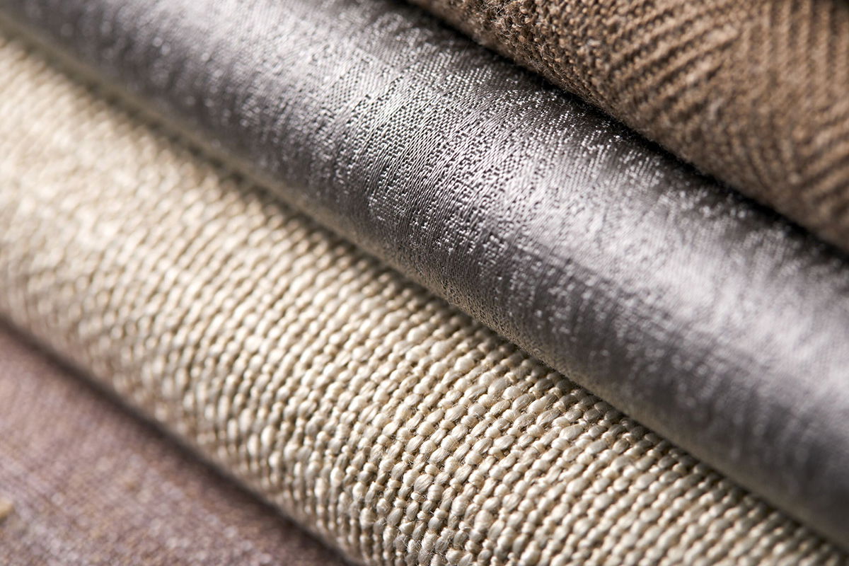 A close up of swatches of various roller shade materials show a variety of colors and textures.