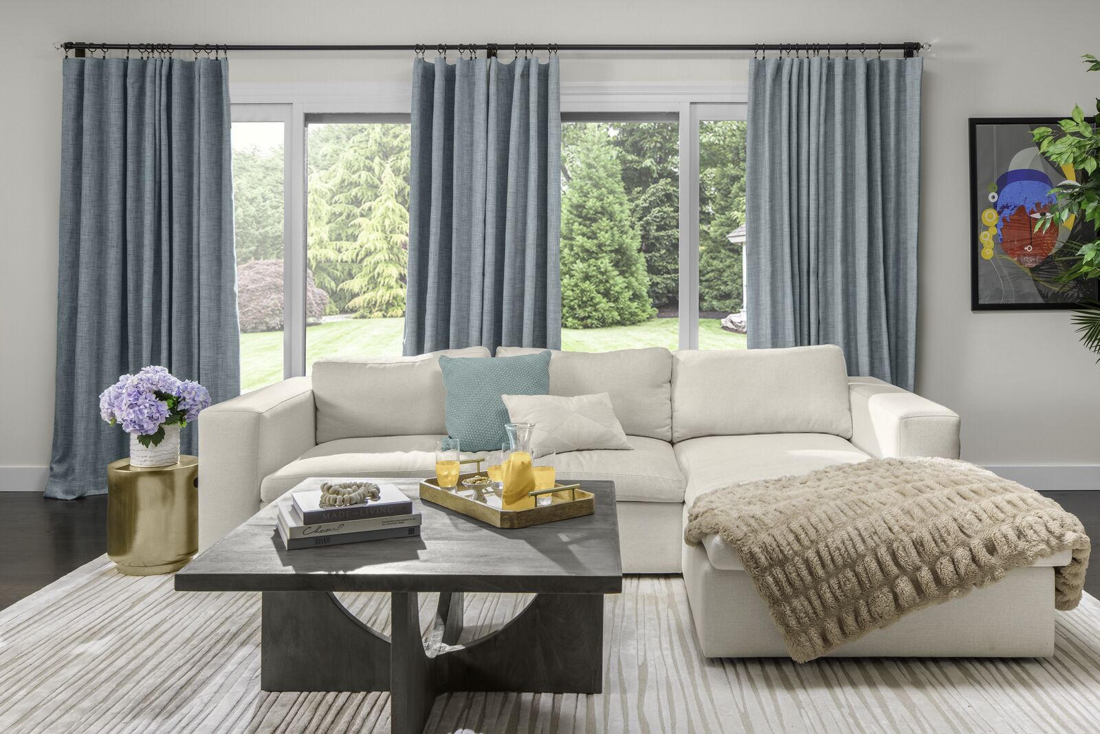 Light teal drapes cover a large sliding glass window in a bright living room.