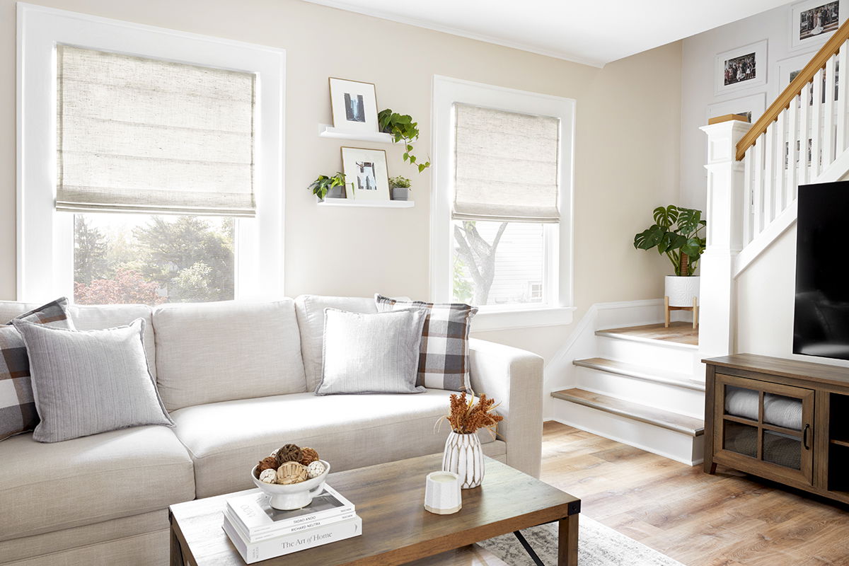 Natural off-white flat fold roman shades in a modern living room.