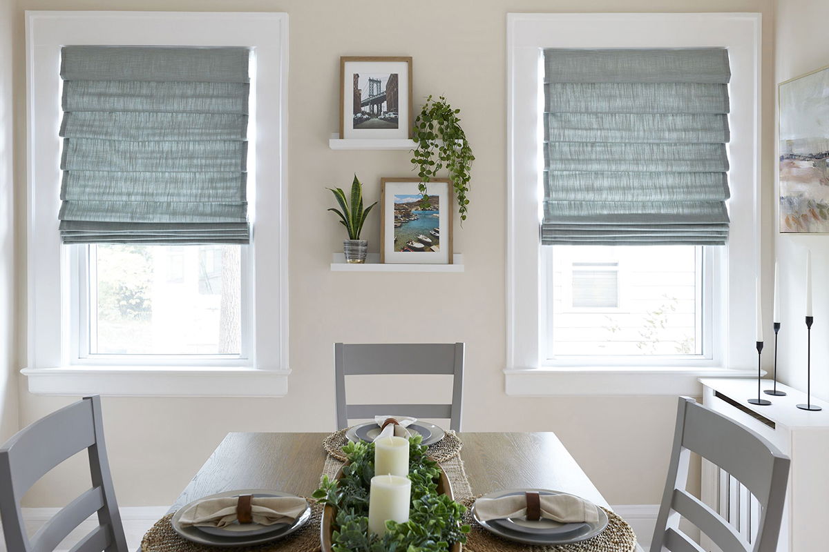 Classic-fold roman shades in sea foam green cover two windows in a small modern kitchen