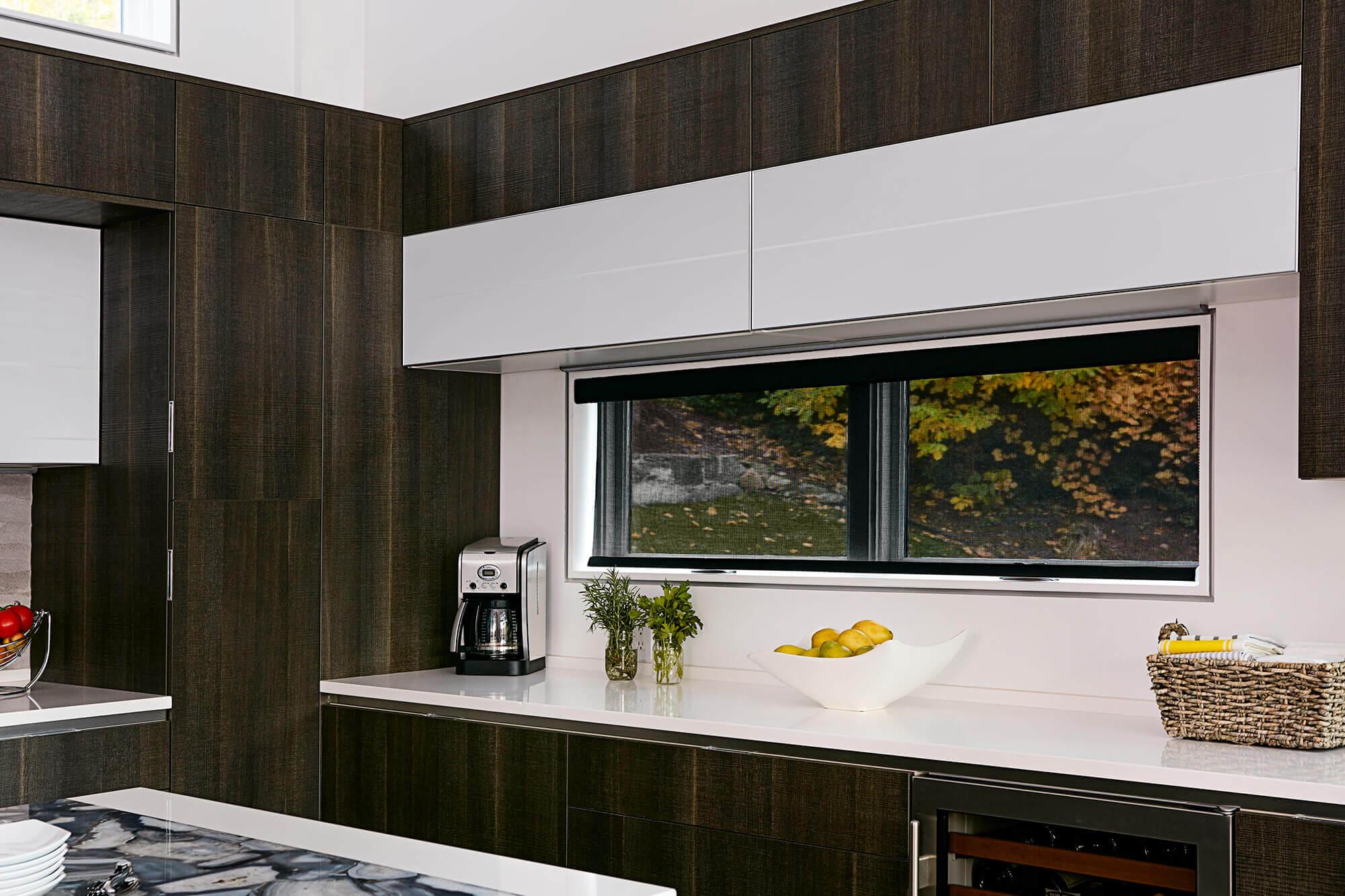 Black solar shades offer a view of the outdoors in a modern kitchen