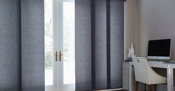 Custom panel track blinds for large windows, providing privacy and a sleek, contemporary look.