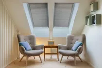 Skylight shades in a room with two chairs, adding style and light control to the space