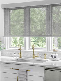 Solar shades in a kitchen above the sink, providing UV protection, glare reduction, and a modern aesthetic