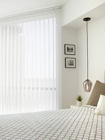 Vertical sheers in a bedroom, offering soft light diffusion, privacy, and a touch of elegance to the space